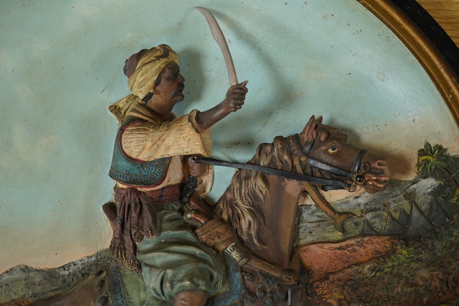 A Johann Maresch cold painted terracotta dish, decorated in relief with a Turk on horseback, 39cm in diameter. Condition - good, painted wood sword blade